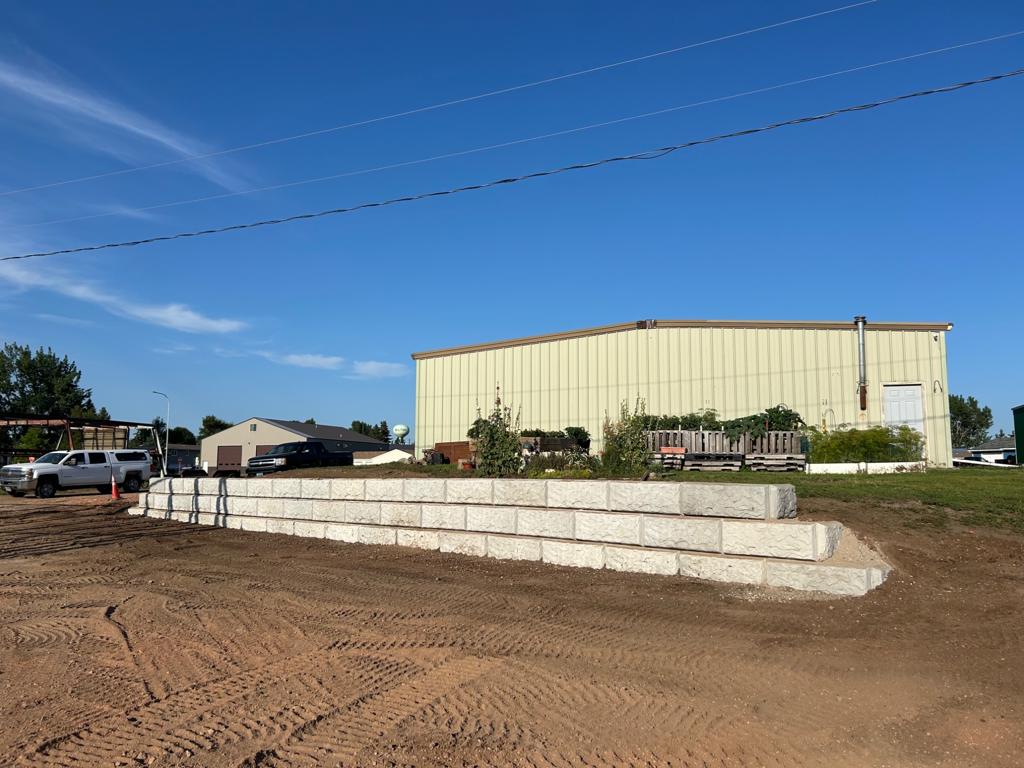 Concrete block retaining wall installation by Dakota Earthworks - durable landscaping solution